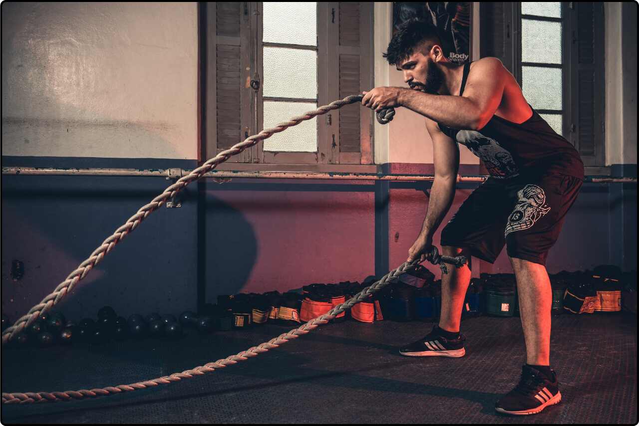 Man grasping a brown rope with both hands, showing a loudly moved.